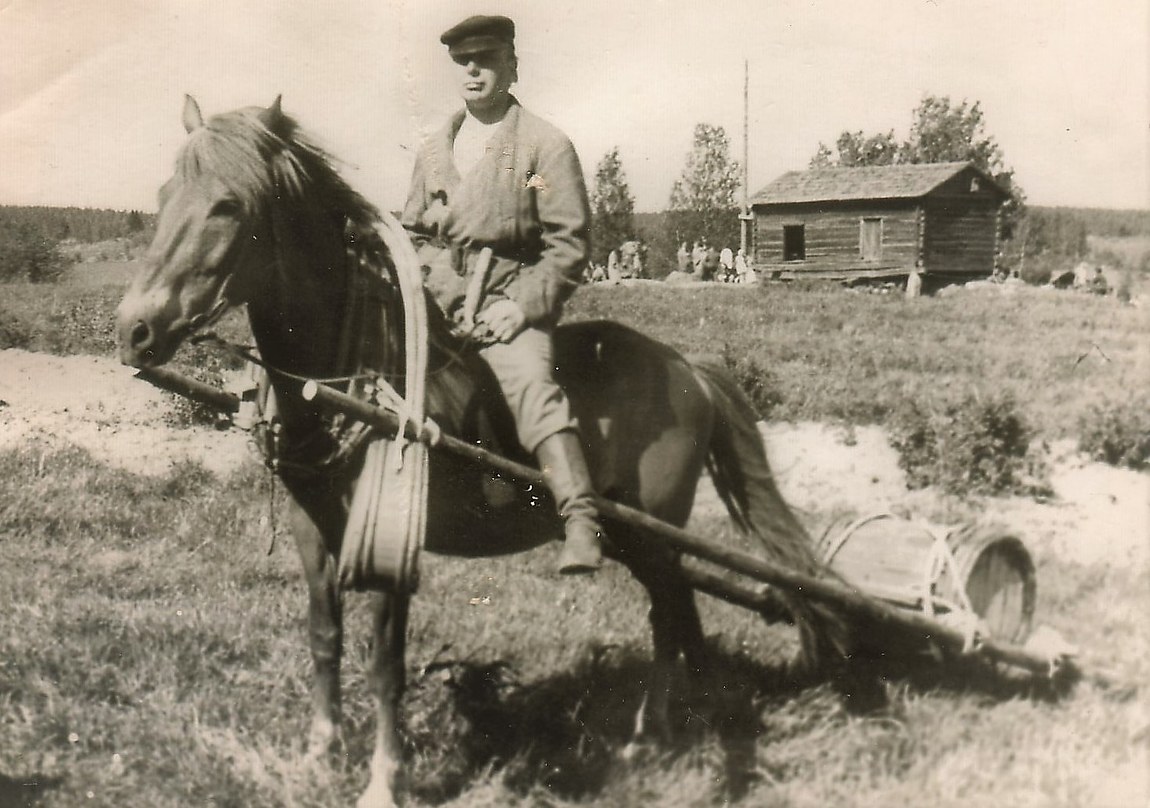 Vanhassa valokuvassa mies hevosen selässä
